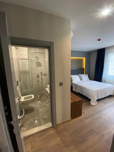 a hotel room with a bed and a shower at Dedehan Hotel in Trabzon