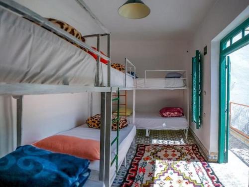 Habitación con 2 literas y alfombra. en The Madrassa en Marrakech