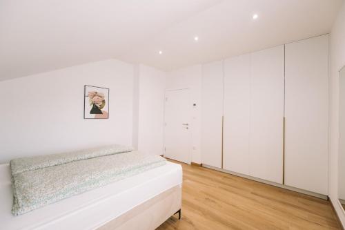 a white bedroom with a bed and white wardrobes at Luxoria in Livno