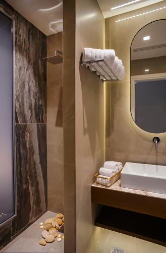 a bathroom with a sink and a mirror at L-Suites in Kavála