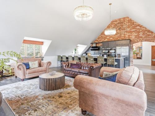 a living room with couches and a table at The Penthouse - Uk52276 in Beccles