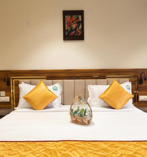 a bedroom with two beds with yellow and white pillows at KG Residency Inn in Thanjāvūr