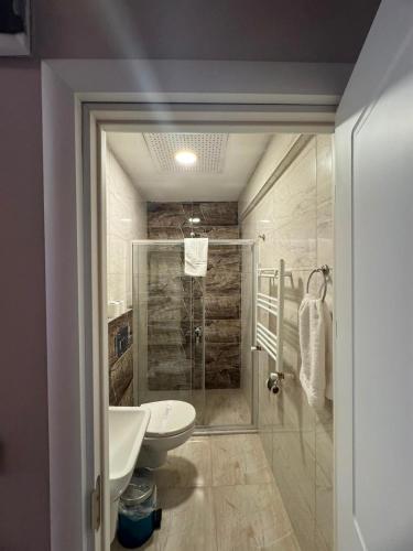 a bathroom with a shower and a toilet and a sink at ATAKAUM AYKA OTEl in Atakum