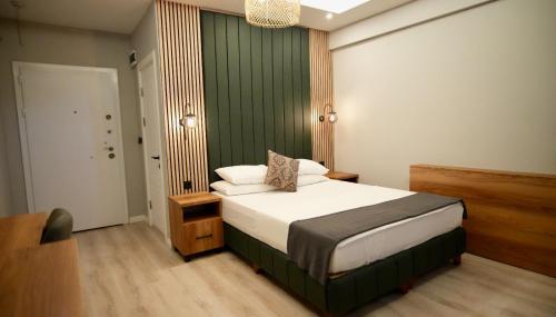 a bedroom with a bed with a green wall at ATAKAUM AYKA OTEl in Atakum