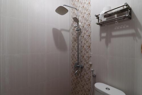 a shower stall in a bathroom with a toilet at Bisma Balcony Homestay in Yogyakarta