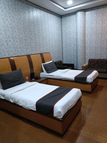 two twin beds in a room with at Hotel Rahul Palace in Nagpur