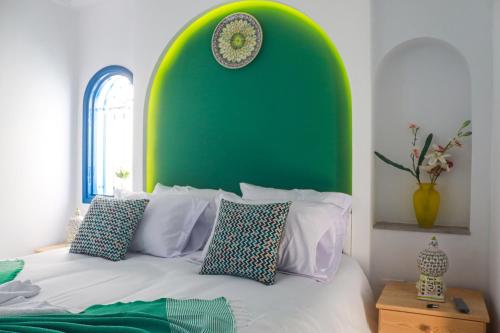 a bedroom with a green headboard and a bed with pillows at Dar Beate Sousse Medina in Sousse