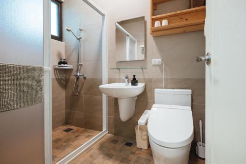 a bathroom with a toilet and a sink and a shower at Tree House Café & Homestay in Tongluo