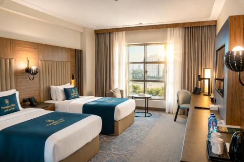 ein Hotelzimmer mit zwei Betten und einem Fenster in der Unterkunft Paradise Nice Hotel Jeddah in Dschidda