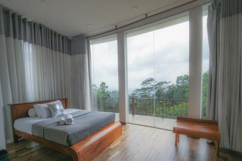 a bedroom with a bed and a large window at Villa Vajrapani in Kandy