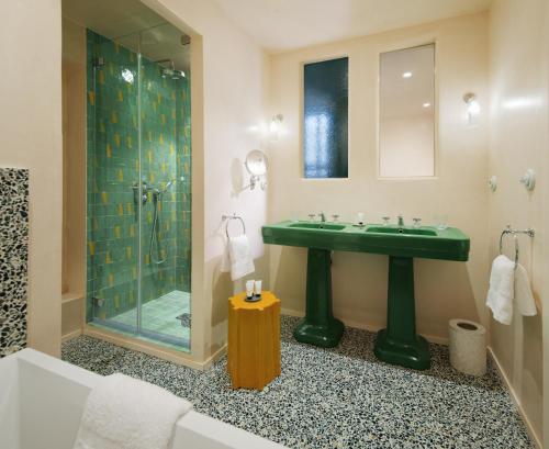 a bathroom with a green sink and a shower at Chez Gratien Hôtel Bistro Spa in Villeneuve-dʼAveyron