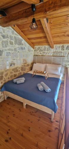 a bed in a room with a stone wall at Olive Stonehouse Sea and Mountain View in Áyios Míron