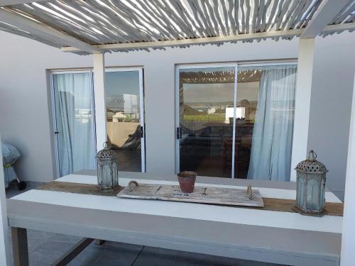 a white table with two vases on top of it at Lieflappie Seaview Stilbaai 400m to the beach in Stilbaai
