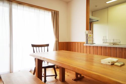a dining room with a wooden table and chairs at 白浜みんと in Shirahama