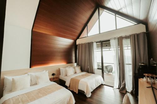 a bedroom with two beds and a large window at Grey Rock Mountain Cabin w/ Jacuzzi in Balamban
