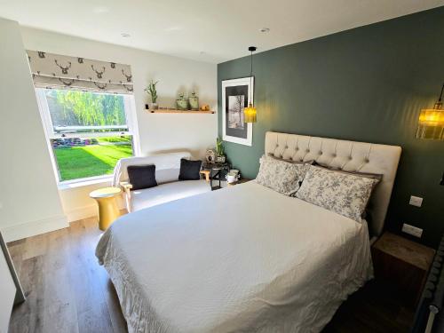 a bedroom with a large bed and a window at Studio 3 - Stylish apartment central to hospital and racecourse in Cheltenham