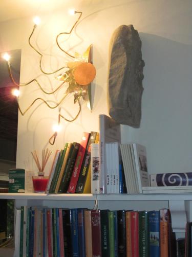 a book shelf with books and a statue on it at Cascina Giardini in Alba