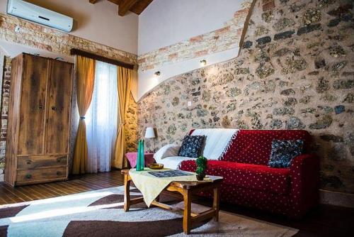 uma sala de estar com um sofá vermelho e uma mesa em Jason's Stone House em Ágios Matthaíos