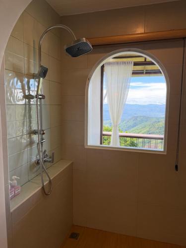 a bathroom with a shower and a window with a view at SUNYA Doichang in Ban Huai Khai