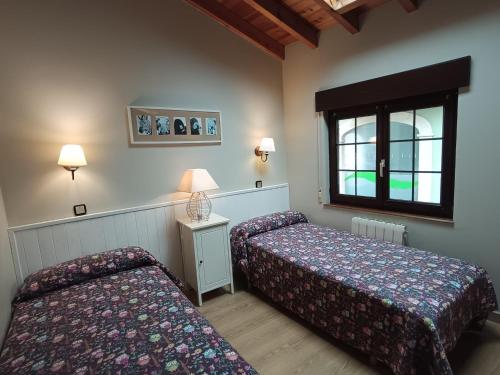 a hotel room with two beds and a window at La casuca in Noja