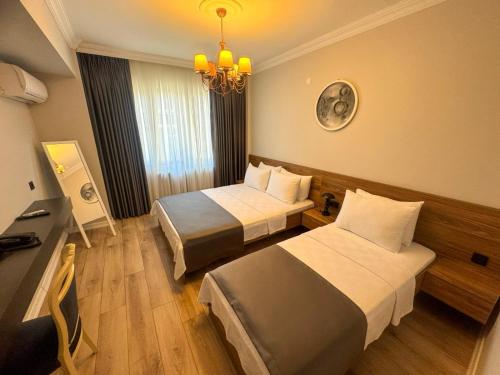a hotel room with two beds and a chandelier at Fethibey Otel in Bartın