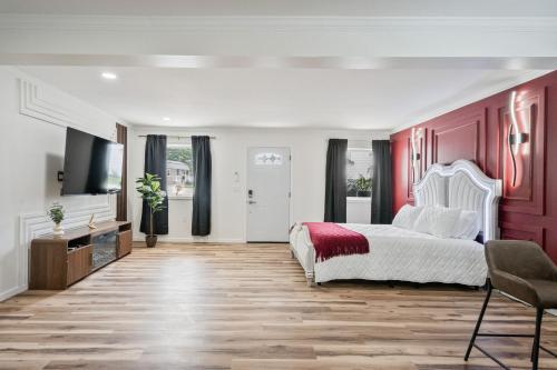 a bedroom with a white bed and red walls at Clair de Lune Studio A Charming Kokomo Stay in Kokomo