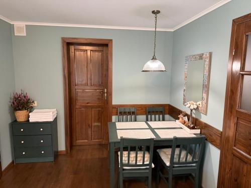 a dining room with a table and chairs and a cabinet at Decor Park Apartament in Karpacz