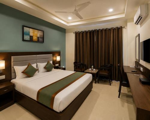 a bedroom with a bed and a desk and a television at Hotel S-mart In Delhi Airport & Free Airport Pickup in New Delhi