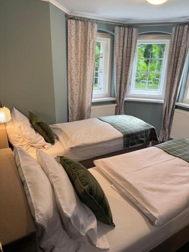 a room with three beds and two windows at Decor Park Apartament in Karpacz
