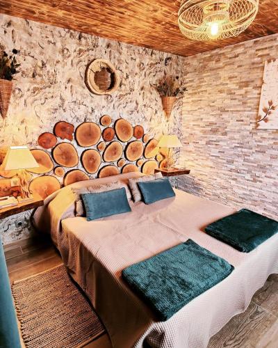 a bedroom with a bed with a pile of logs on the wall at Au Barthas in Caylus