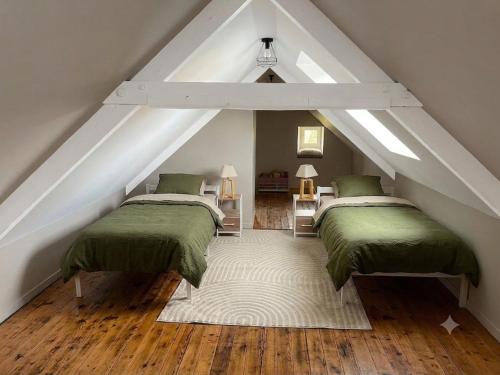 two beds in a attic room with green sheets at Le Nid de Réville, Maison proche de la mer in Réville