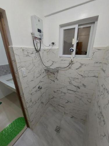 a bathroom with a marble shower with a window at CMJ Private Resort in Banaba Cerca