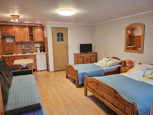 ein Wohnzimmer mit zwei Betten und eine Küche in der Unterkunft Aga Mielenko Pokoje i Apartamenty in Mielenko