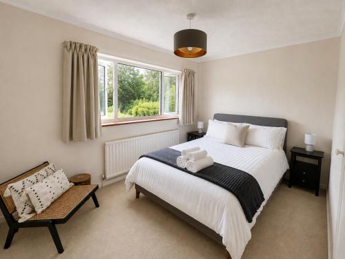 a bedroom with a large white bed and a chair at Three Bed Detached Property in Frimley