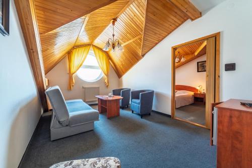 a room with a mirror and chairs and a bed at Hotel Ferum in Šaca