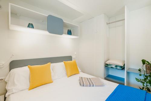 a bedroom with a bed with yellow pillows at Massa Marina Camping in Marina di Massa