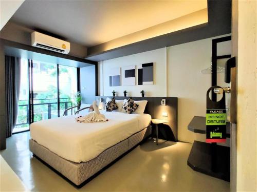 a bedroom with a large bed and a balcony at Silom Studios in Bangkok