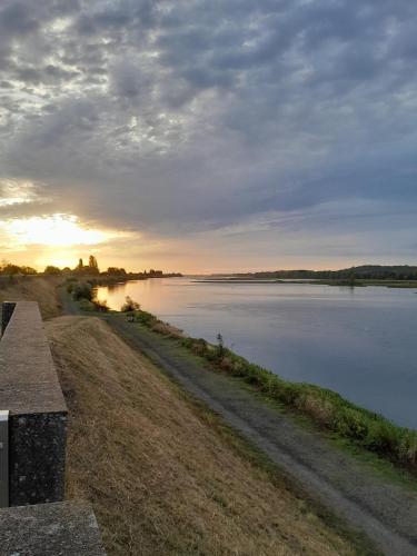 a view of a body of water with the sunset at Camping Port la Vallée in Saint-Mathurin