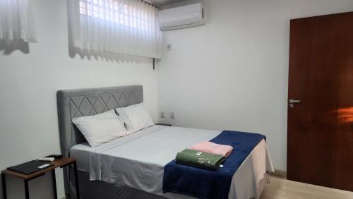 a small bedroom with a bed and a door at Casa requinte estilo Ap próx Fema Unesp in Assis