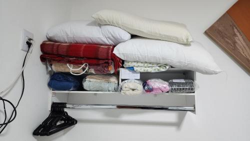 a pile of pillows sitting on a shelf at Casa requinte estilo Ap próx Fema Unesp in Assis
