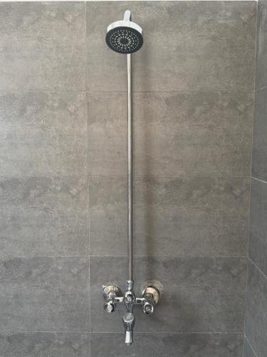 a shower with a shower head in a bathroom at Kove Hotel & Resort in Naran