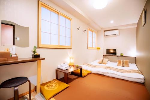 a small room with a bed and a table at Hotel 向日葵 in Osaka
