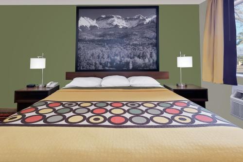 a bedroom with a large bed with two lamps at Super 8 by Wyndham Denver Central in Denver