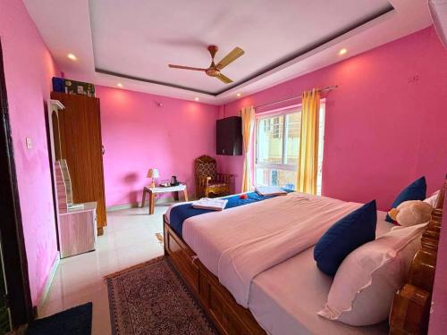 a bedroom with a large bed with pink walls at Heritage Waves in Puri