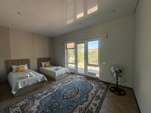 a bedroom with two beds and a fan and a rug at Mountain View in Türgen