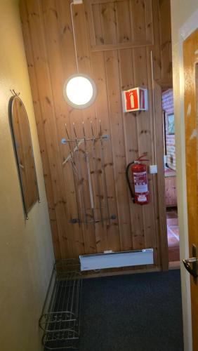 a room with a wooden wall with a door at Fengselet Gjestegård in Leira