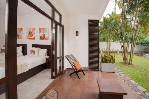 a bedroom with a bed and a bench in a room at Nature Trails Boutique Hotel in Unawatuna