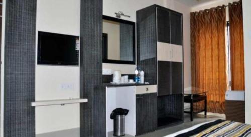 a bedroom with a bathroom with a sink and a mirror at Mayor Hotel in Siliguri