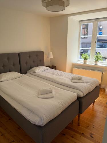 a large bed in a room with a window at Apartments Strandgatan Visby in Visby