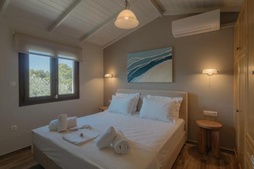 a bedroom with a bed with towels on it at Millstone Summerhouse in Pachis